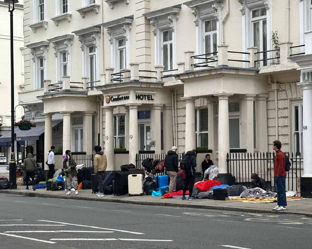 Migranti protestujú na chodníku pred londýnskym hotelom, absurdné požiadavky